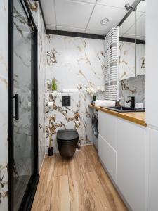 a bathroom with a toilet in the middle of a kitchen at Warsaw Modern Stay Apartamenty Kasprzaka 29 in Warsaw