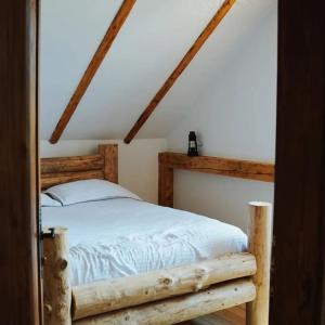 - une chambre mansardée avec un lit en bois dans l'établissement Cuibul cu Trufe, 