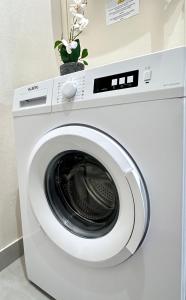 a white washing machine in a room with a plant at 1562 - Cosy Montmartre in Paris Olympic Games 2024 in Paris