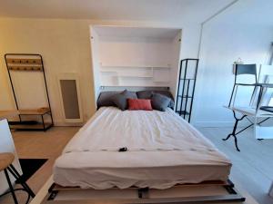 1 dormitorio con cama grande y almohada roja en Studio Marseillan-Plage, 1 pièce, 4 personnes - FR-1-326-781, en Marseillan