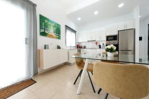 een keuken met een glazen tafel en 2 stoelen bij Villa Cassia - Private Pool, Foosball, BBQ, Air-Con and SAT Tv By Lanzarote Vacation Homes in Playa Blanca