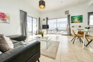 een woonkamer met een bank en een tafel bij Villa Cassia - Private Pool, Foosball, BBQ, Air-Con and SAT Tv By Lanzarote Vacation Homes in Playa Blanca