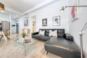 een woonkamer met een zwarte leren bank en een glazen tafel bij Villa Cassia - Private Pool, Foosball, BBQ, Air-Con and SAT Tv By Lanzarote Vacation Homes in Playa Blanca +37 foto's
