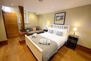 a bedroom with a large bed and a couch at Forest Farm Barn Hampshire in Bishops Waltham