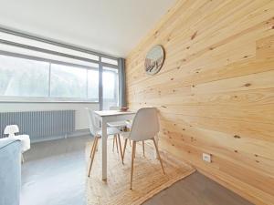 a dining room with wooden walls and a table and chairs at Le 307, Vue pistes in La Bresse