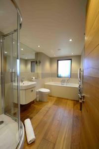 a bathroom with a shower and a tub and a sink at Forest Farm Barn Hampshire in Bishops Waltham