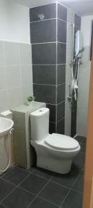 La salle de bains est pourvue d'une douche et de toilettes blanches. dans l'établissement Hillpark Residens, à Semenyih