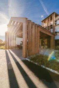 um edifício de madeira com o sol brilhando sobre ele em Hotel Reiters Finest Family em Bad Tatzmannsdorf