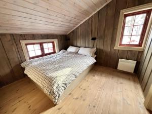 um quarto com uma cama num quarto de madeira em Stor og flott hytte med fantastisk utsikt em Geilo