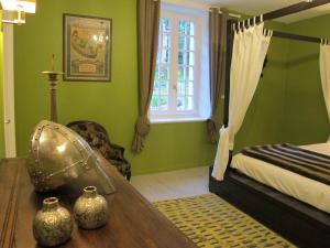 1 dormitorio con paredes verdes y 1 cama con mesa de madera en Le Coteau du Seigneur, 
