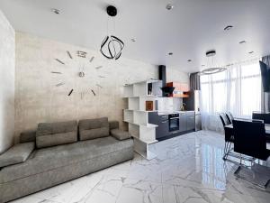 sala de estar con sofá y reloj en la pared en 45 Pearl Magnificent Apartment, en Odessa