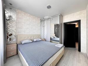 1 dormitorio con 1 cama grande y espejo en 45 Pearl Magnificent Apartment, en Odessa