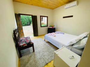 ein Schlafzimmer mit einem Bett und einem Stuhl und einem Fenster in der Unterkunft Ferrari Casa Nostra in Santa Teresa