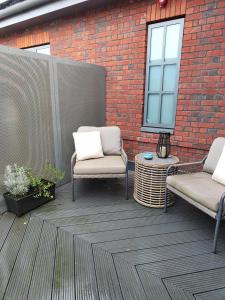 a patio with two chairs and a brick wall at The Heyford Hotel in Upper Heyford