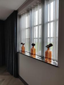 three bottles sitting on a shelf in front of a window at The Heyford Hotel in Upper Heyford