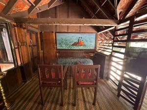 uma sala de jantar com uma mesa e duas cadeiras em Elephant Courtyard- A Heritage Homestay em Alappuzha