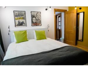 a bedroom with a large bed with two green pillows at Vila Sunset in Eforie Nord