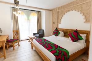 a bedroom with a large bed with a desk and a chair at Small World Country Club in Athi River
