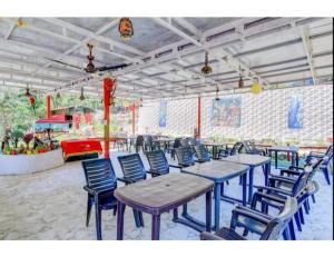 a group of tables and chairs in a restaurant at Aqua Splash Camp, Rishikesh in Rishīkesh
