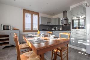 a kitchen with a wooden table and chairs at Chez nicole et alain in Ugine