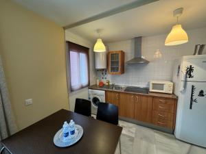 Il comprend une cuisine équipée d'une table et d'un réfrigérateur. dans l'établissement ECIJA Plata Rota Apartment by Cadiz4Rentals, à Rota