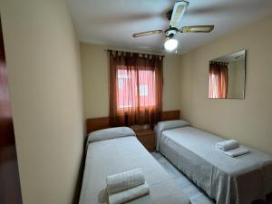 - une chambre avec 2 lits et un ventilateur de plafond dans l'établissement ECIJA Plata Rota Apartment by Cadiz4Rentals, à Rota