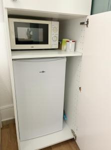 a microwave on top of a white cabinet in a kitchen at Charmant studio neuf proche de paris in Bagnolet