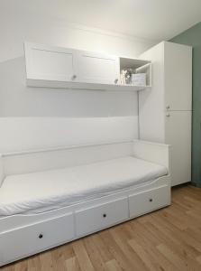a white room with a bed and white cabinets at Charmant studio neuf proche de paris in Bagnolet