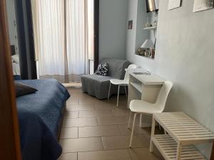 アチレアーレにあるJonio B&Bのベッド、テーブル、椅子が備わる小さな客室です。