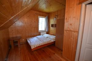 a small bedroom with a bed in a wooden room at Domyletnie Pobierowo Dom 100m2 z własną działka in Pobierowo