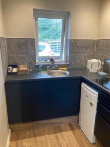 a kitchen counter with a sink and a window at Skyefall Self Catering in Uig