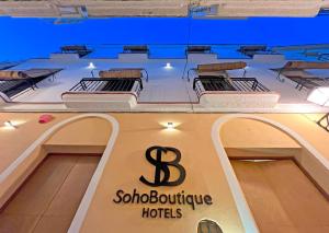 a sign for a boutique hotel with three beds at Soho Boutique Cádiz in Cádiz