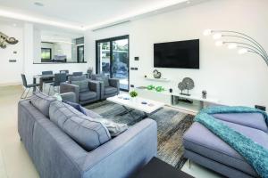uma sala de estar com dois sofás e uma televisão em Vale do Lobo Modern Villa With Pool by Homing em Vale do Lobo