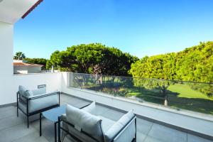 a balcony with a view of a golf course at Vale do Lobo Modern Villa With Pool by Homing in Vale do Lobo