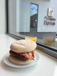 a sandwich sitting on a plate next to a window at Holiday Inn Express Manchester City Centre Arena by IHG in Manchester