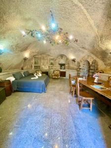 1 dormitorio con cama y mesa en una cueva en Cueva romántica - Jacuzzi en La Cabrera