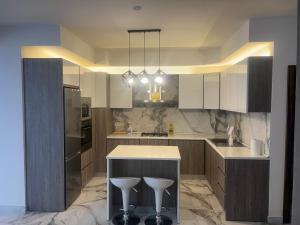a kitchen with white cabinets and a island with stools at Maisonette 2 in Munxar