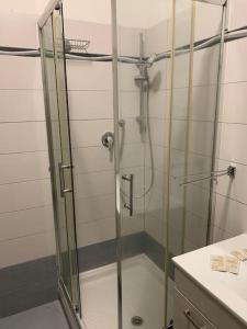 La salle de bains est pourvue d'une douche avec une porte en verre. dans l'établissement casa la Frontiera, à Vintimille