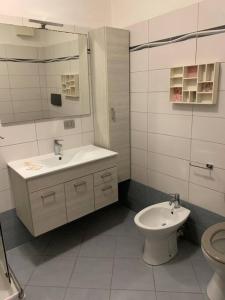 La salle de bains blanche est pourvue d'un lavabo et de toilettes. dans l'établissement casa la Frontiera, à Vintimille