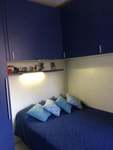 - une chambre avec un lit bleu et des armoires bleues dans l'établissement casa la Frontiera, à Vintimille