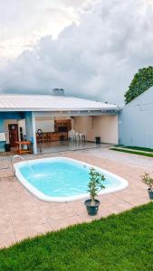 een zwembad voor een huis bij Macadamia Espaço de Festas e hospedagem in Lucas do Rio Verde