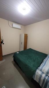 een kamer met een bed en een koelkast. bij Macadamia Espaço de Festas e hospedagem in Lucas do Rio Verde