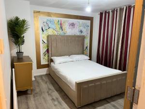 um quarto com uma cama e um quadro na parede em 3 bedroom house Colchester em Colchester