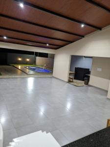una gran habitación vacía con una piscina en el fondo en Macadamia Espaço de Festas e hospedagem, en Lucas do Rio Verde