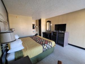 a hotel room with a bed and a flat screen tv at Super 8 by Wyndham Arkadelphia Caddo Valley Area in Arkadelphia