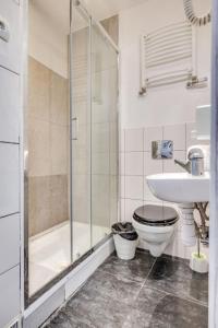 een badkamer met een douche, een toilet en een wastafel bij Hostel Kattowitz in Katowice