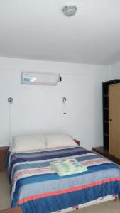 Un dormitorio con una cama con una toalla. en Tacita de Plata Apart en San Salvador de Jujuy