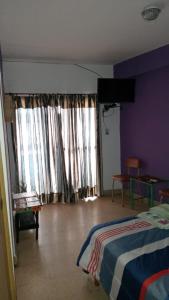 um quarto com uma cama e uma parede roxa em Tacita de Plata Apart em San Salvador de Jujuy