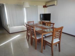 a dining room table with chairs and a television at EDIFICIO BARROS in Olavarría