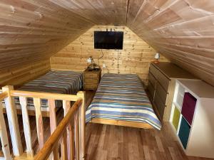 pokój w drewnianym domku z łóżkiem i telewizorem w obiekcie Luxdomki Kąty Rybackie w Kątach Rybackich